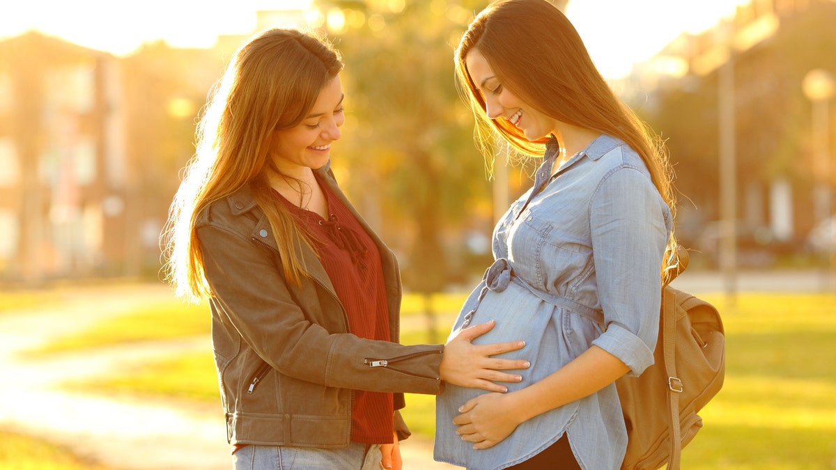 Woman touching pregnant belly