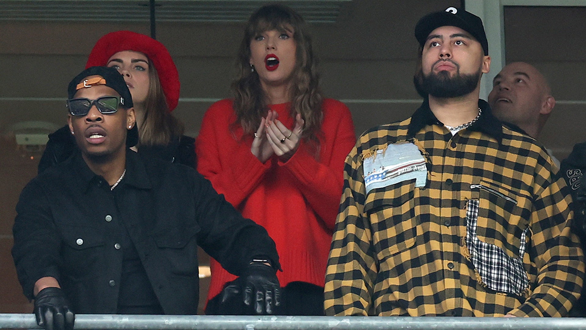 Cara Delevingne, Taylor Swift and Ross Travis look on during the second quarter in the AFC Championship Game