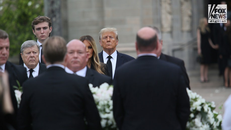Former President Donald Trump looks on alongside his wife Melania, son Barron, and father-in-law Viktor Knavs as the coffin carrying the remains of the former First Lady’s mother Amalija Knavs