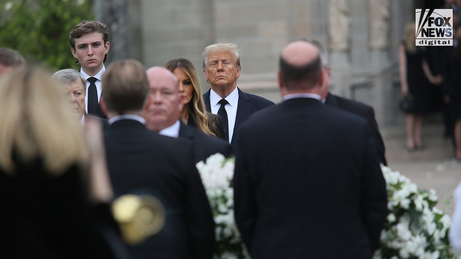 Former President Donald Trump looks on alongside his wife Melania, son Barron, and father-in-law Viktor Knavs as the coffin carrying the remains of the former First Lady’s mother Amalija Knavs is carried into the Church of Bethesda-by-the-Sea