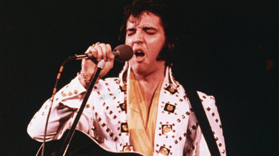 Elvis Presley wearing a white rhinestone suit 