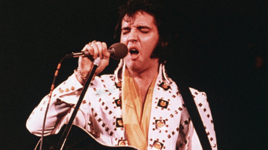 Elvis Presley wearing a white rhinestone suit