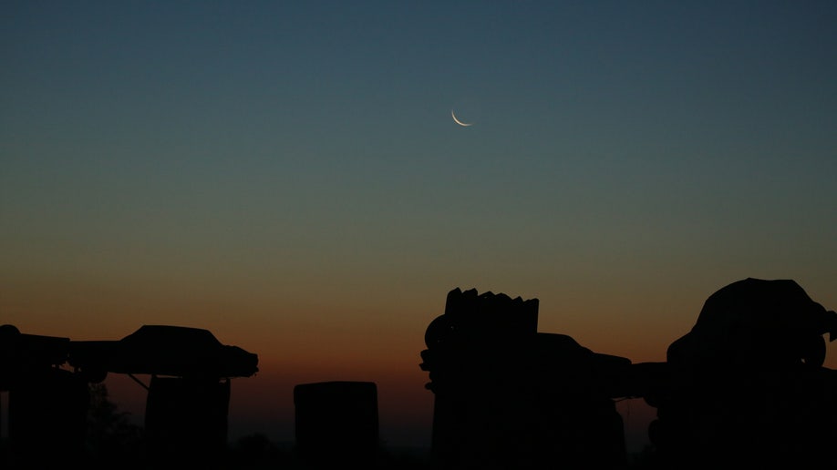 Moon rising before the sun over Carhenge