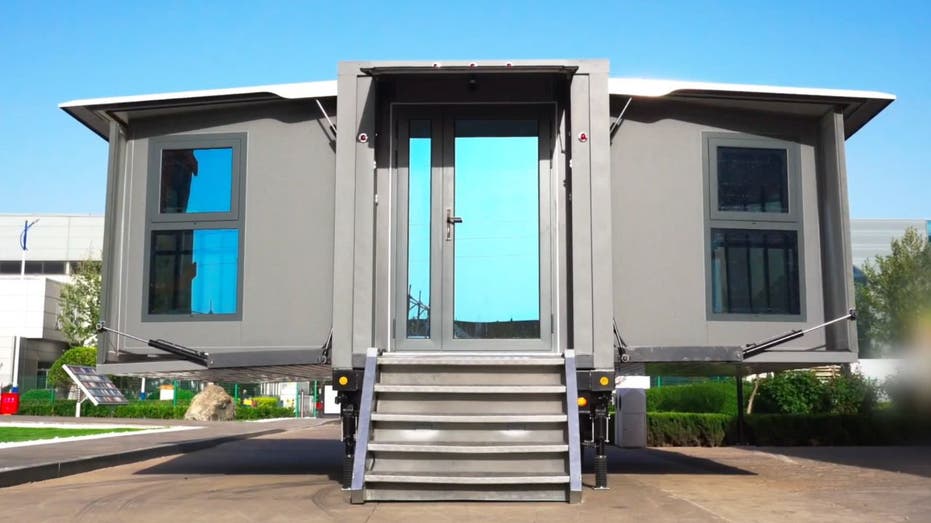 With the press of a button, this tiny house folds into a box that you can tow anywhere