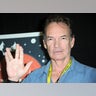 Gary Graham in a jean shirt doing the 'Star Trek' symbol