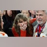 Taylor Swift waves as she walks with Ed Kelce