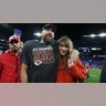 Travis Kelce smiles alongside Taylor Swift