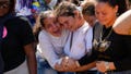 A sister of miner Santiago Mora, left, cries with other relatives as he is buried at the cemetery in La Paragua, Bolivar state, Venezuela, Thursday, Feb. 22, 2024. The collapse of an illegally operated open-pit gold mine in central Venezuela killed at least 14 people and injured several more, state authorities said Wednesday, as some other officials reported an undetermined number of people could be trapped.