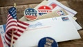 Absentee Ballot and campaign buttons on a wood surface.