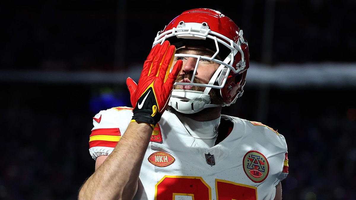 Travis Kelce blwoing a kiss into the stands