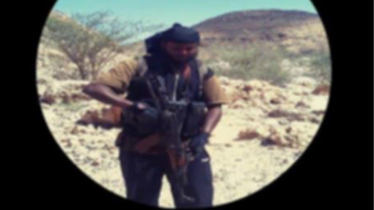 An alleged photo of the suspect holding an AK-47 in the desert of Somalia