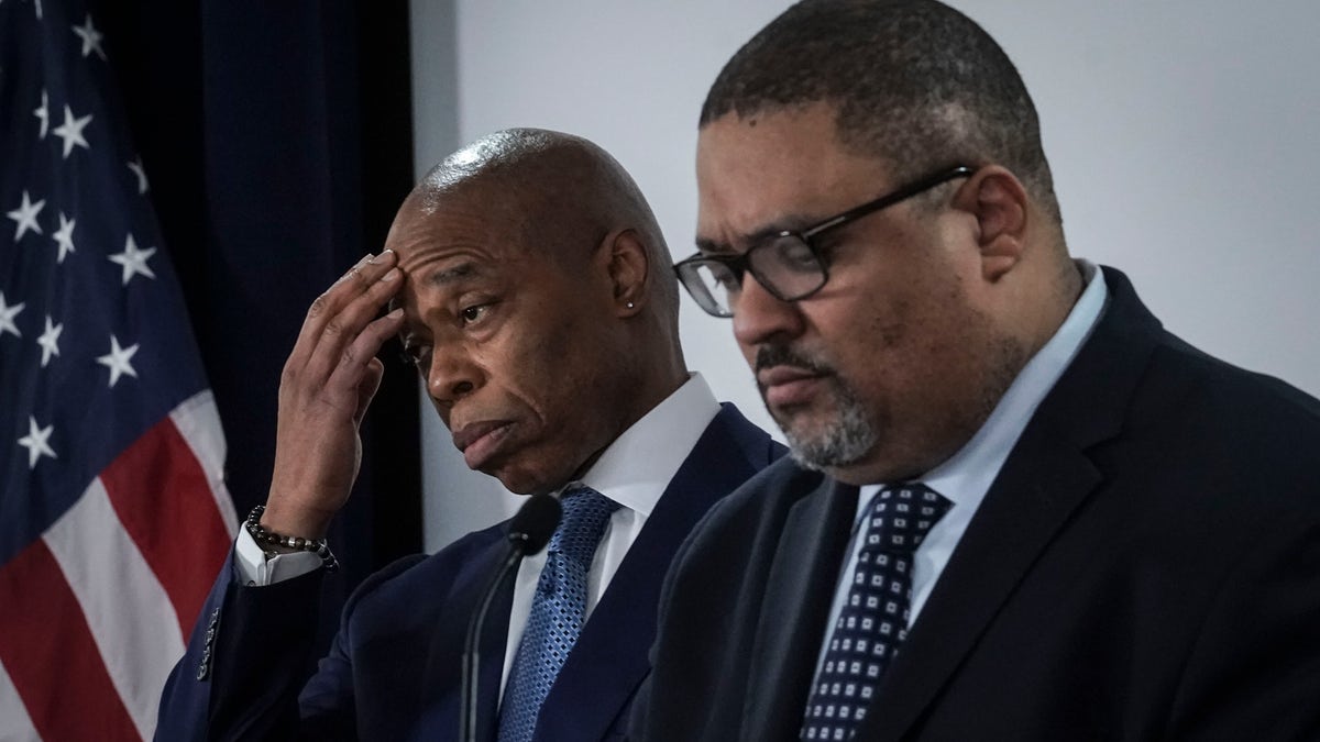 Mayor Eric Adams, left, and District Attorney Alvin Bragg, right, listen during a press conference where they announced several charges for migrants involved in a Times Square brawl with police, Thursday, Feb. 8, 2024, in New York. 