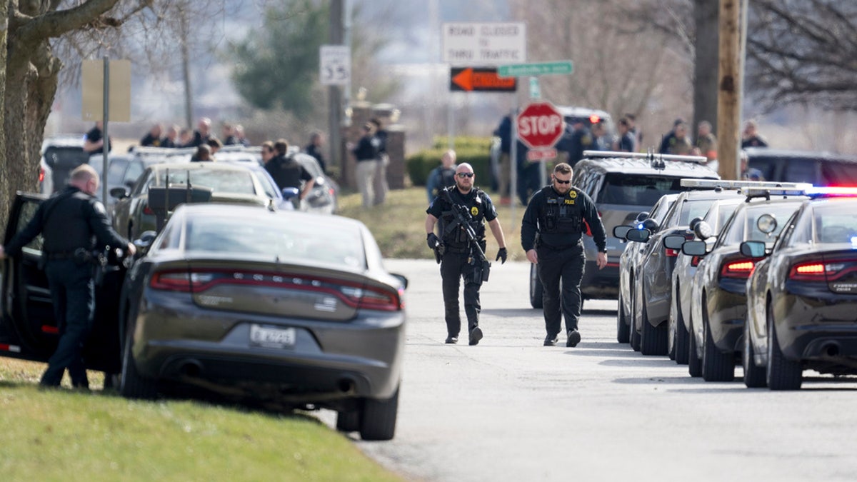 Law enforcement officials and medical personnel work the scene of an officer involved shooting near the intersection of Elsea Smith Road and Budschu Road on Thursday, in Independence, Mo. 