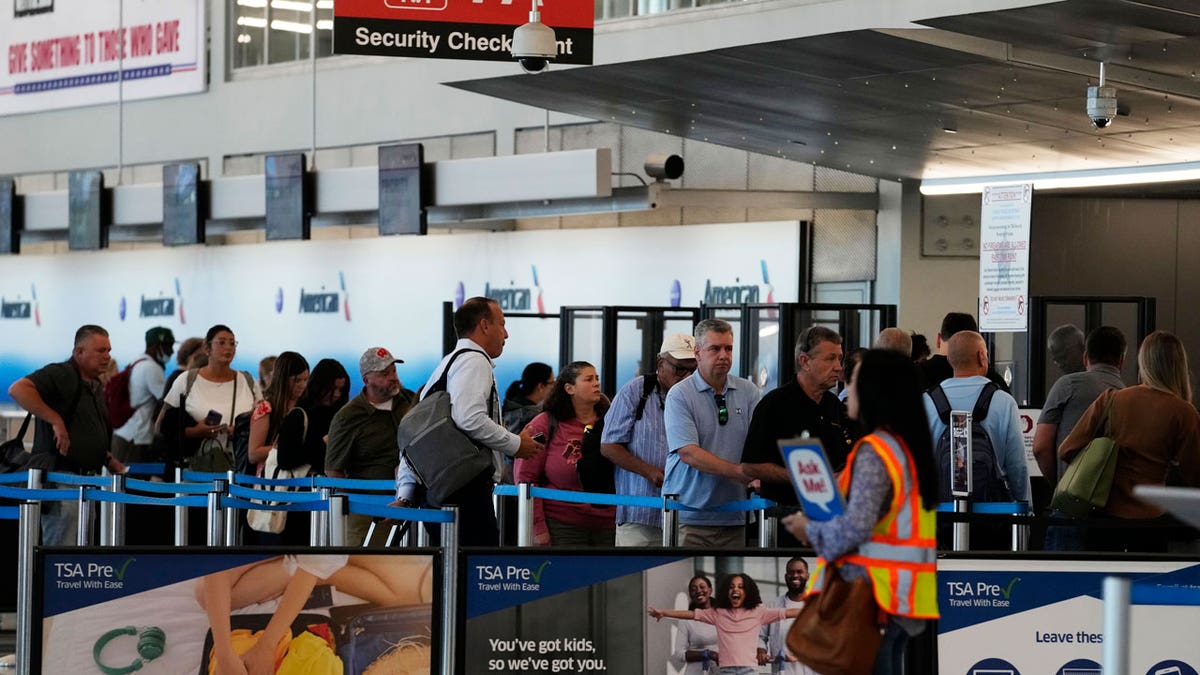 Travelers wait to go through a security check point at O'Hare International Airport in Chicago