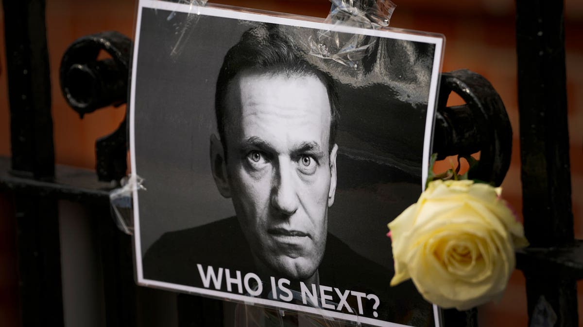 A flower and a image are near arsenic a tribute to Russian leader Alexi Navalny