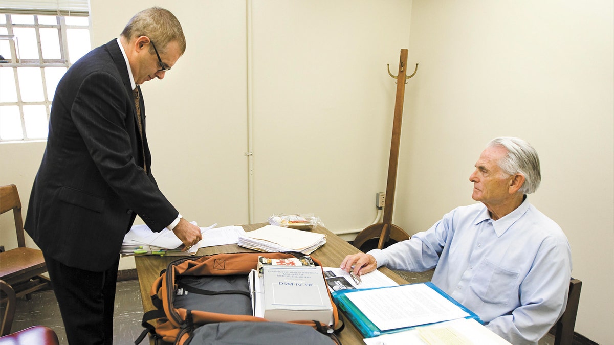 Bruce Davis speaks with attorney in prison room