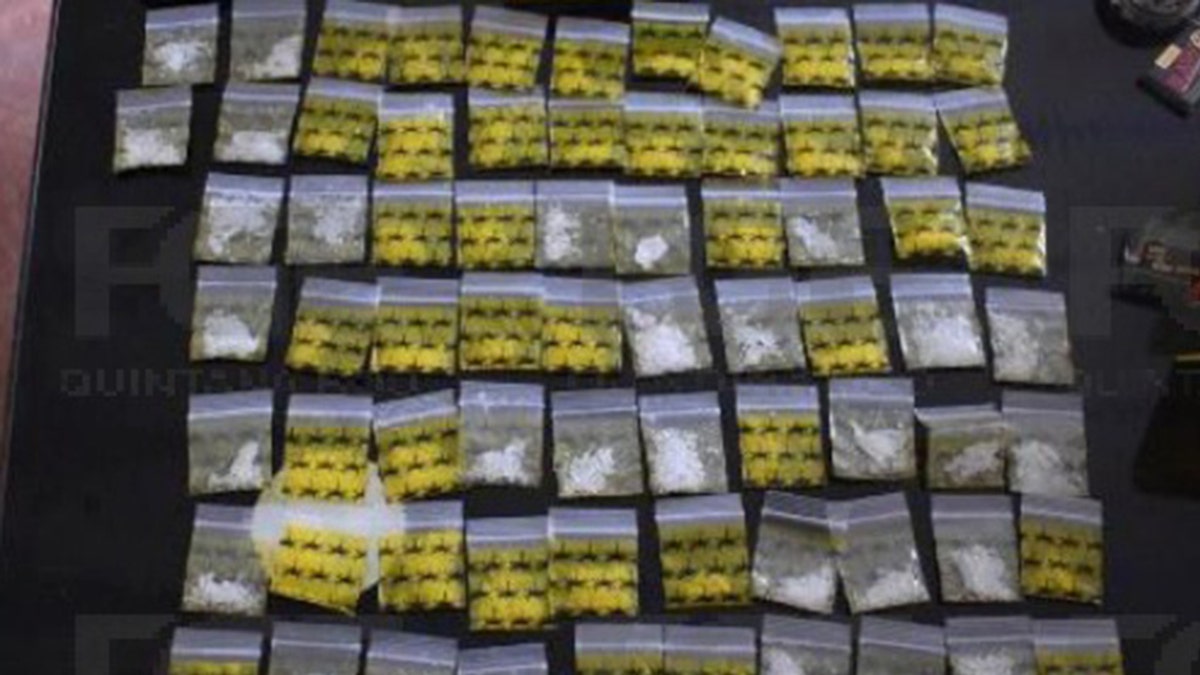 Yellow and clear tiny bags on a table, filled with substances similar to marijuana and meth