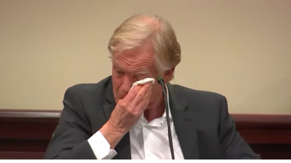 Dave Halls wipes his eyes while testifying