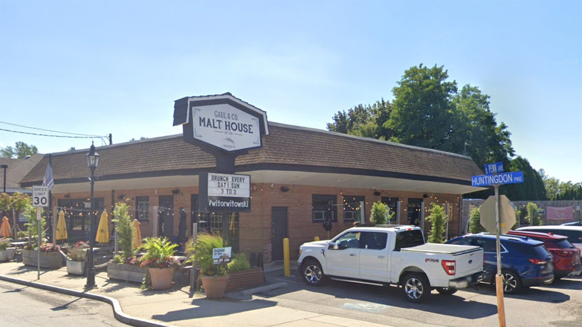 Caul & Co. Malt House sign outside brick restaurant in PA, with white truck, blue SUV, red SUV and white SUV parked beside it, tree, blue sky