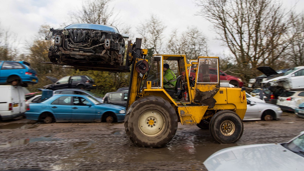 forklift carrying crushed car