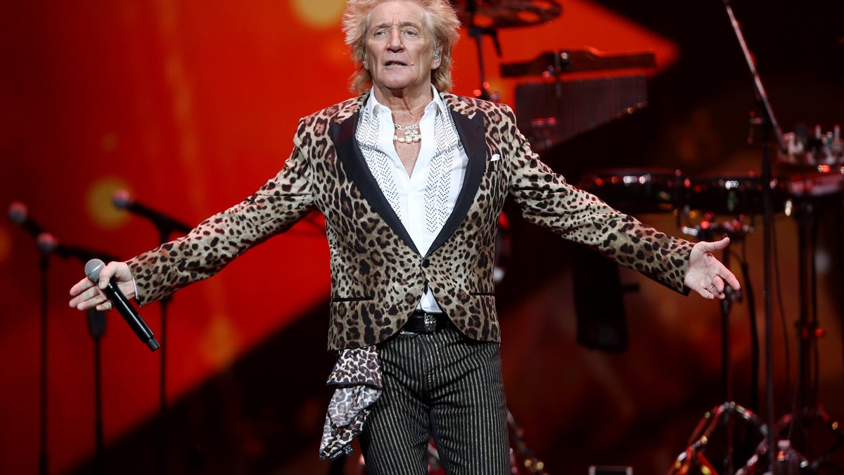 rod stewart with arms spread wide onstage