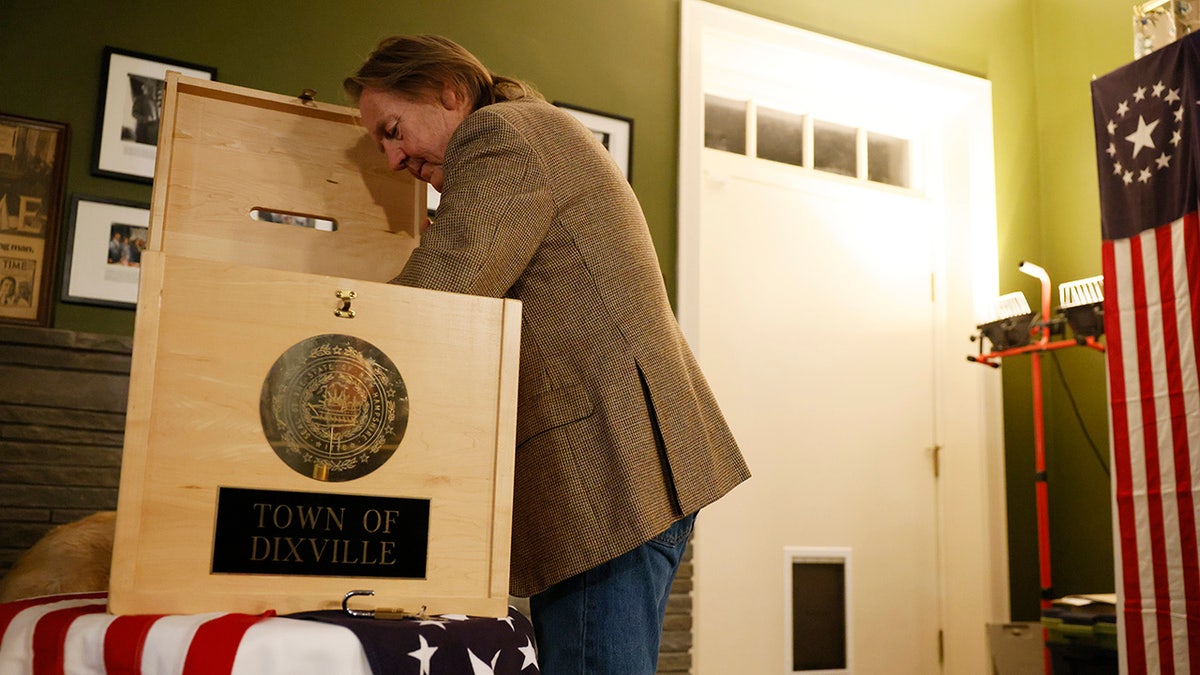 Dixville Notch, NH – January 23: Dixville Notch Town host Tom Tillotson reaches into the ballot box to collect the first ballots in the New Hampshire Primary. Nikki Haley won Dixville Notch 6-0. (Photo by Jessica Rinaldi/The Boston Globe via Getty Images)