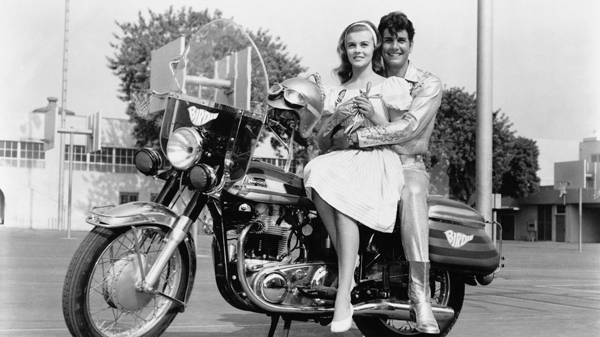 Ann-Margret with her male co-star on top of a motorcycle