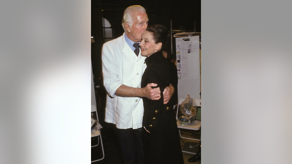 Hubert de Givenchy kissing Audrey Hepburn on the forehead