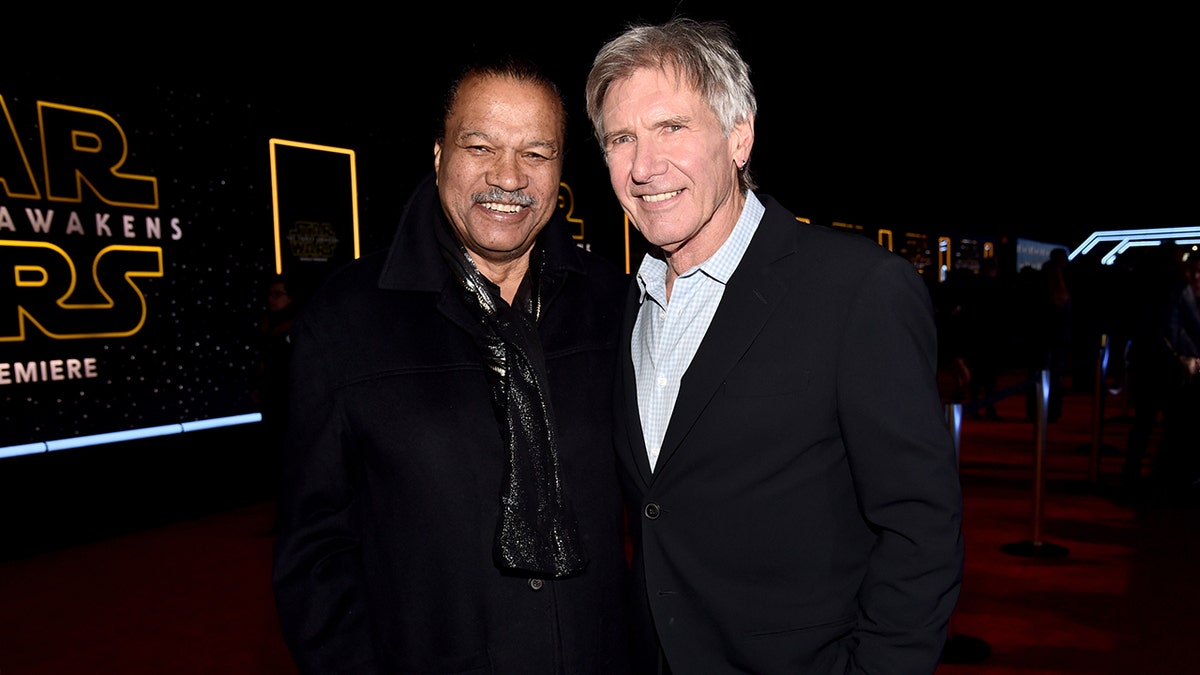 Billy Dee Williams and Harrison Ford posing together and smiling