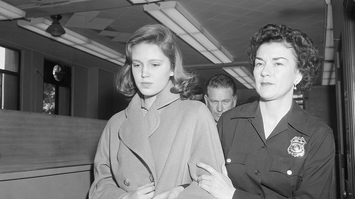 Cheryl Crane looking serious and being accompanied by a woman