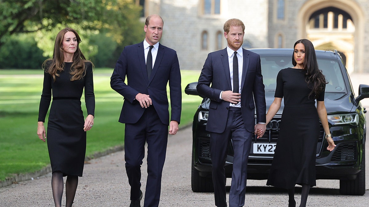The Prince and Princess of Wales with the Duke and Duchess of Sussex wearing matching black outfits walking in front of a car