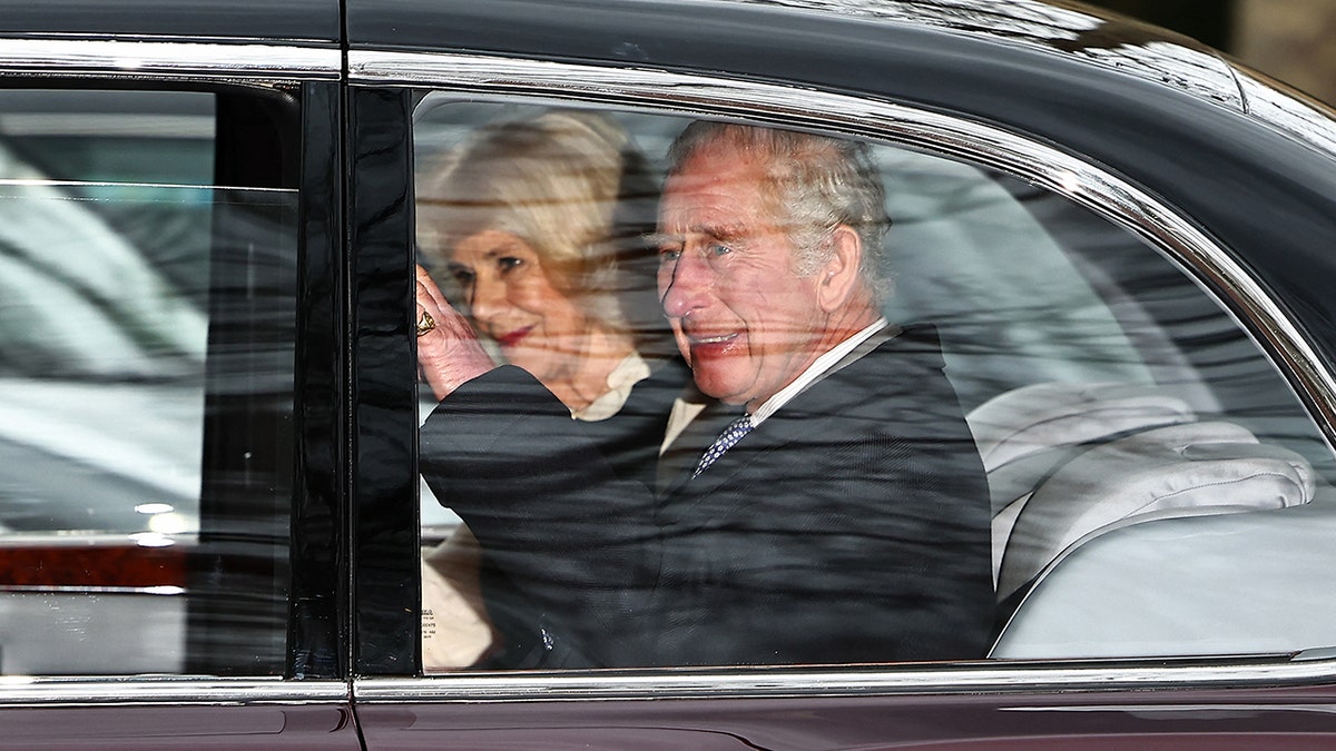 King Charles inside a car next to Queen Camilla