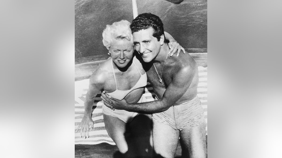 Lana Turner wearing a white bikini with her boyfriend Johnny Stompanato