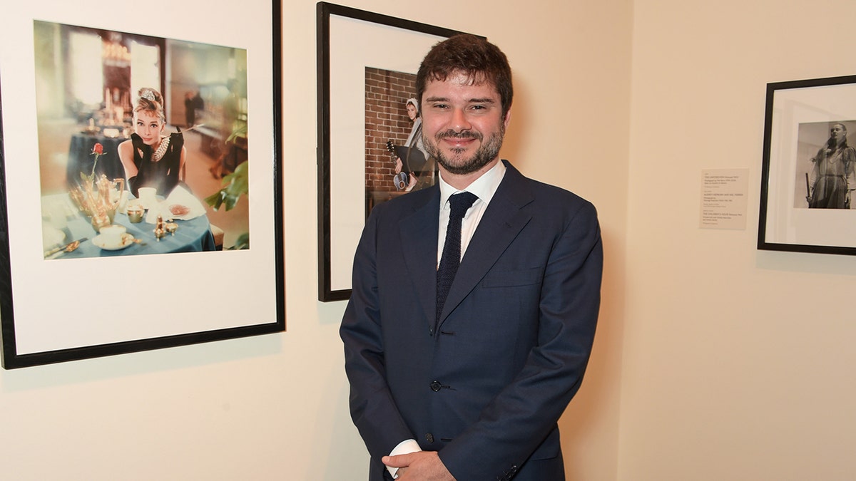 Luca Dotti posing in front of portraits of his mother