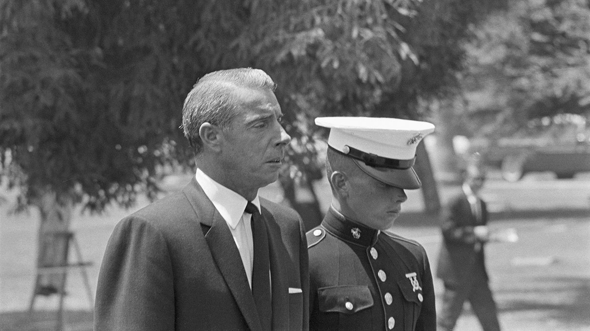Joe DiMaggio looking sad next to his son at Marilyn Monroes funeral