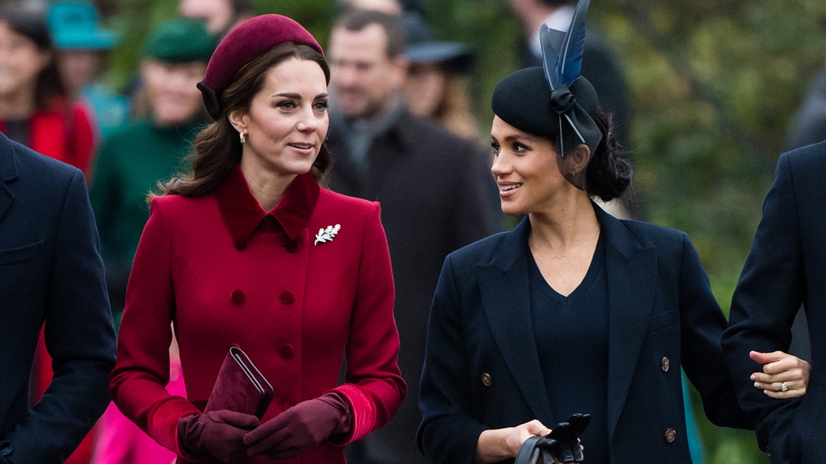 Kate Middleton and Meghan Markle walking next to each other and talking