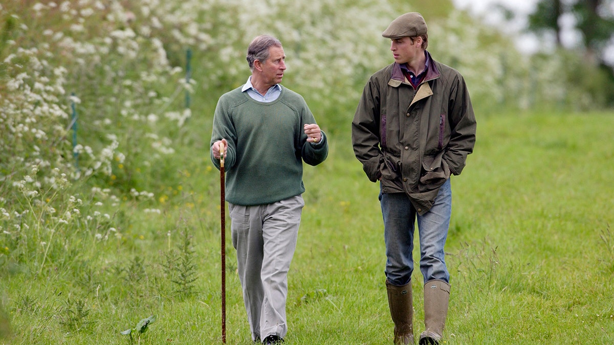 Prince William and King Charles walking on a field