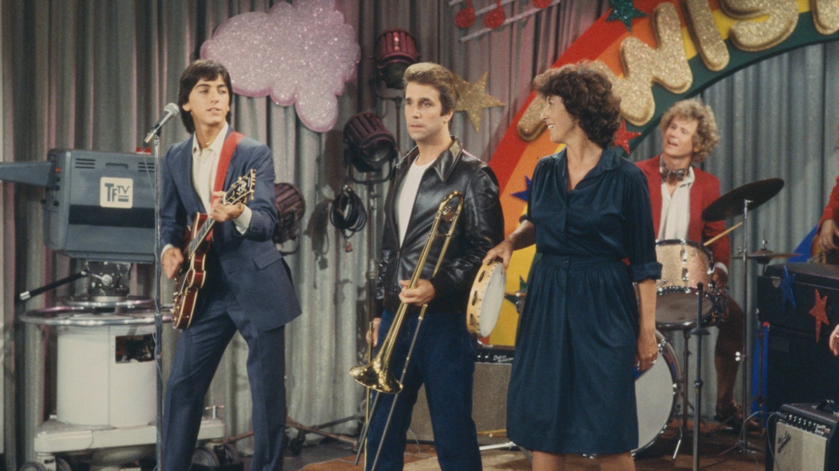 Ellen Travolta standing next to Henry Winkler and Scott Baio on the set of Happy Days