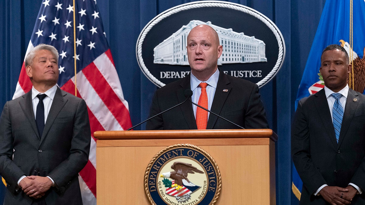 Acting ICE Director Patrick J. Lechleitner (middle at podium in the DOJ), Deputy Secretary of Homeland Security John K. Tien (left) and Assistant Attorney General Kenneth A. Polite, Jr. of the Justice Department's Criminal Division (right)