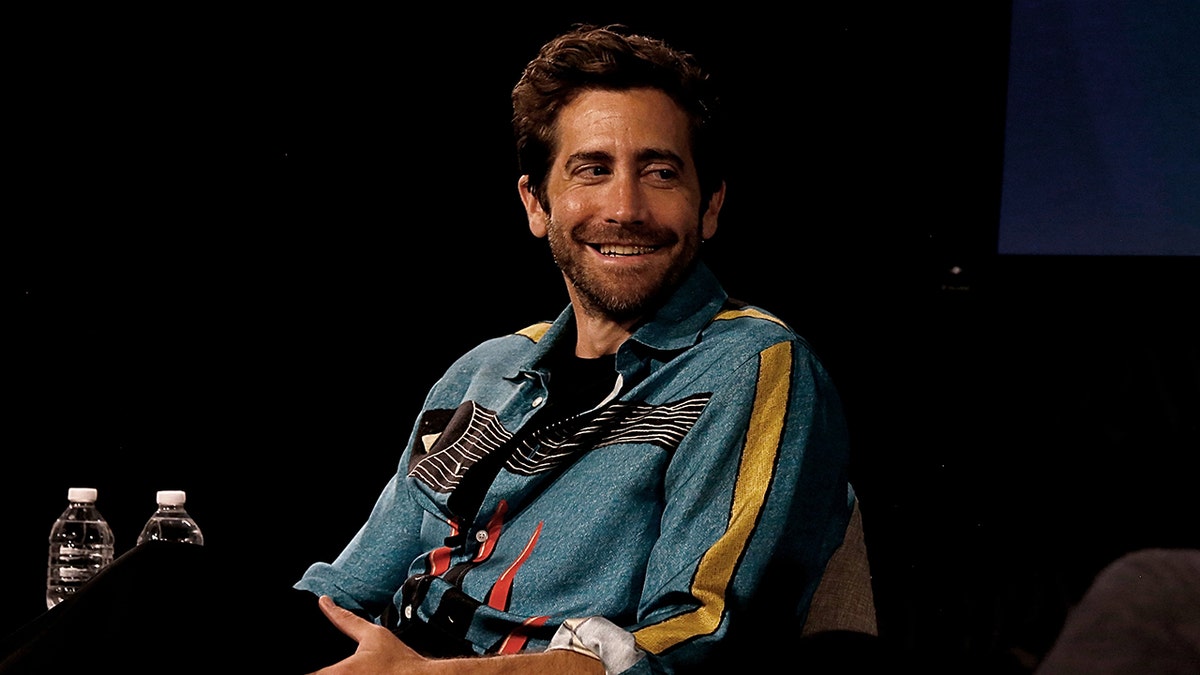 Jake Gyllenhaal sitting on stage