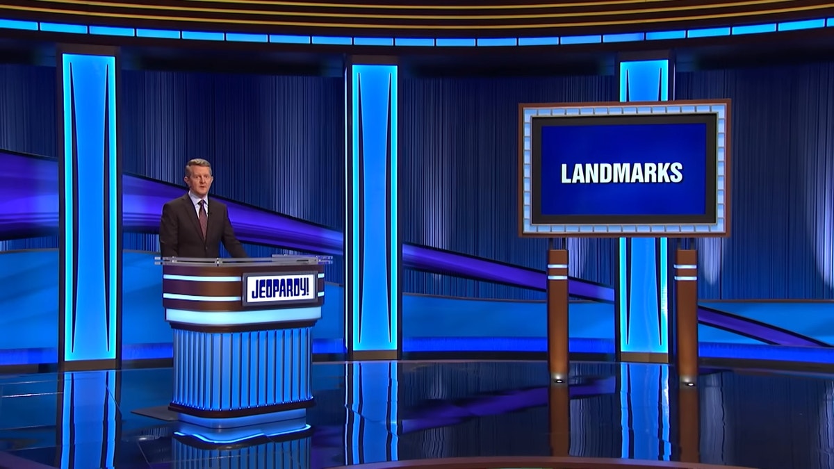 Ken Jennings standing at podium on "Jeopardy!" set