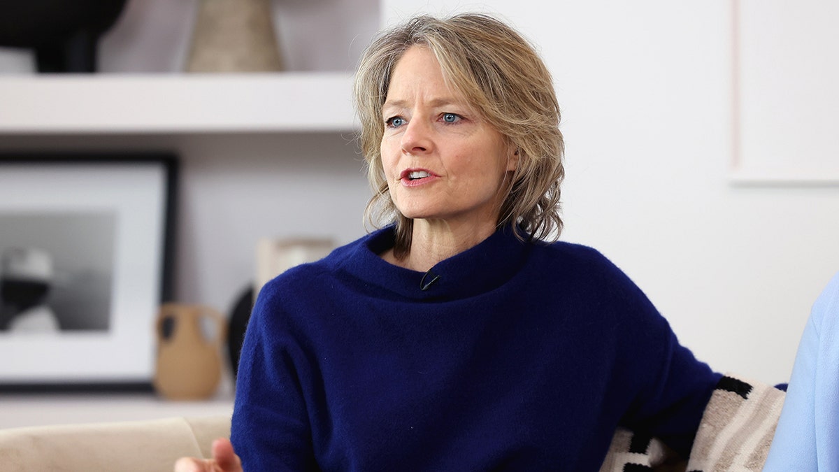 Jodie Foster sitting on a couch and speaking