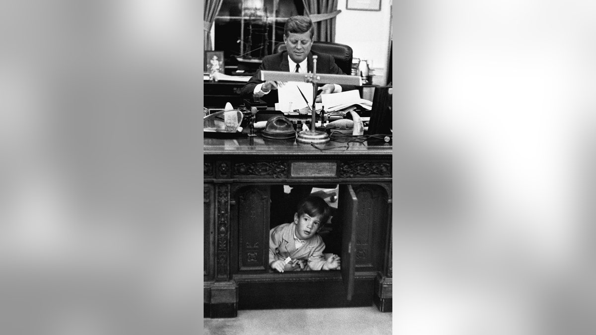 John F. Kennedy Jr. explorando el escritorio de su padre