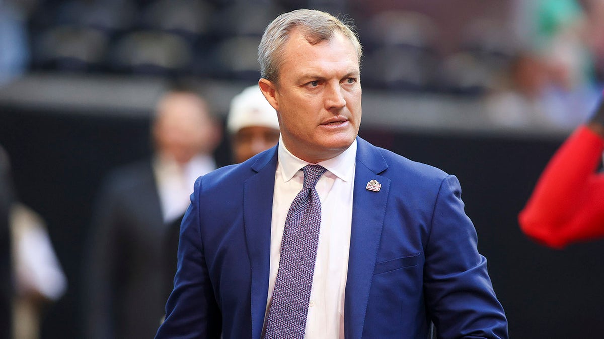 49ers executive John Lynch stands on the football field