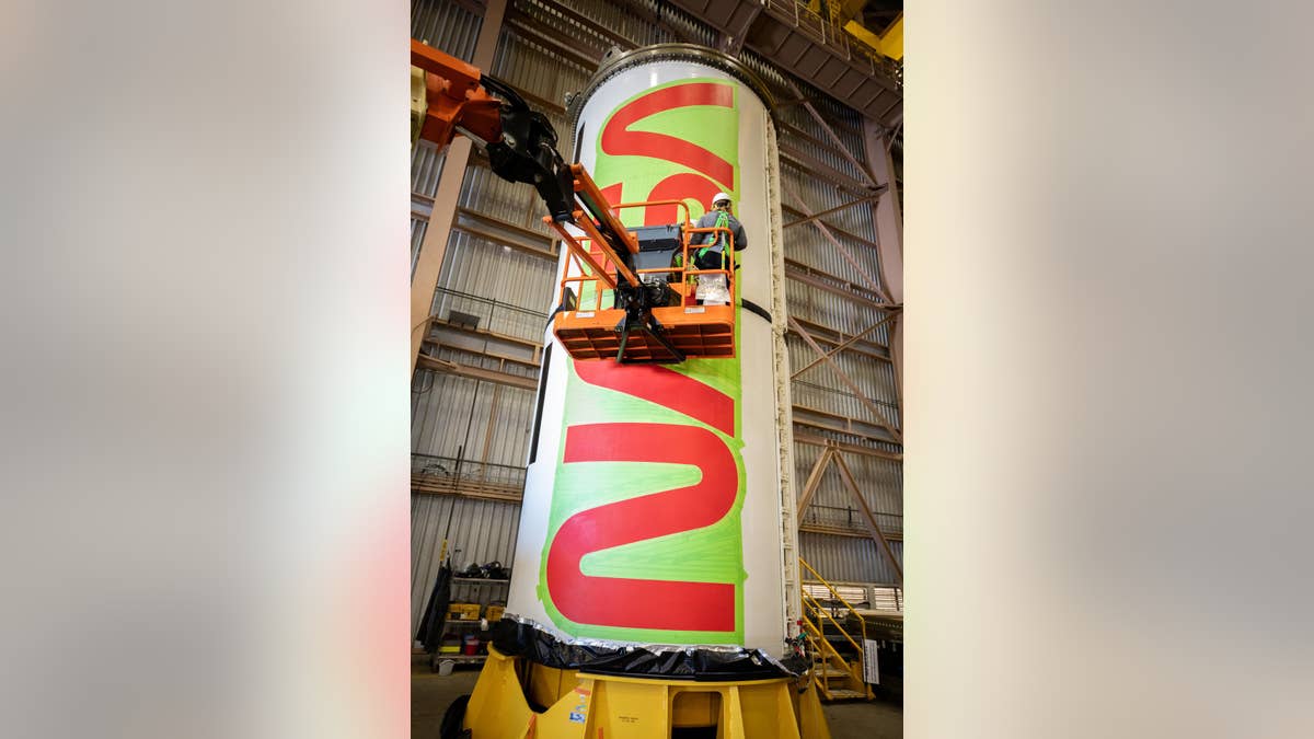 EGS workers painting NASA worm logo on rocket booster