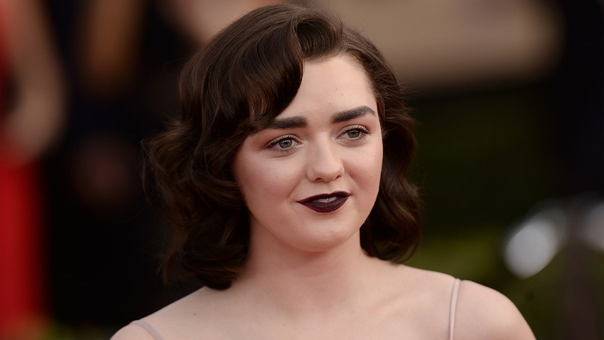 Maisie Williams poses on a red carpet in 2017