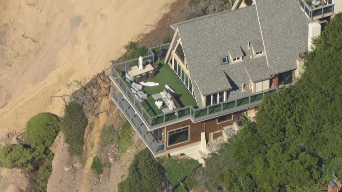 A home has come desperately close to falling into the ocean after a large chunk of coastline collapsed during a recent storm.