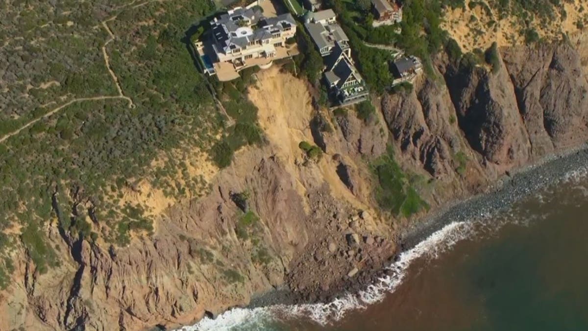 Waves crash against bottom of cliff