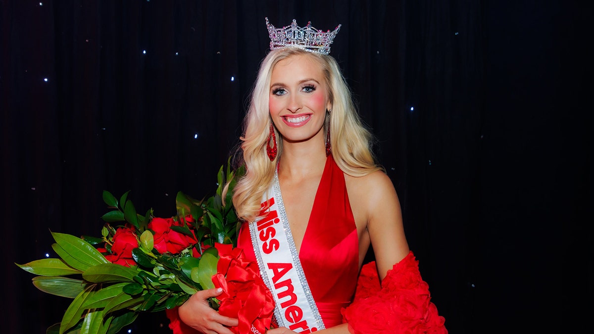 Madison Marsh smiling wearing a red dress and sash