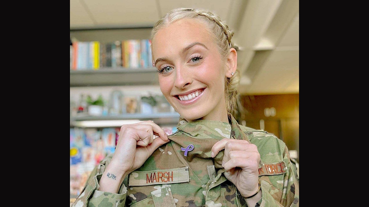 Madison Marsh in her military uniform showing off her pancreatic cancer pin